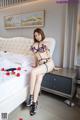 A woman sitting on top of a bed in a bedroom.