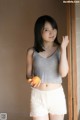 A young woman holding an orange in her hand.