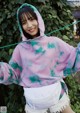 a woman wearing a purple and green tie dye hoodie