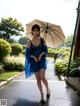 A woman in a blue dress holding an umbrella.