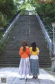 Two women walking up a set of stairs in a park.