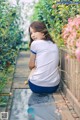 A woman sitting on a wooden walkway next to a fence.