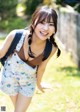 A young woman with a backpack smiles at the camera.