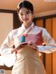 A woman in a white and pink hanbok is posing for a picture.