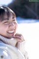 A woman in a white sweater smiles at the camera.