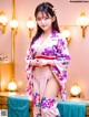 A woman in a pink kimono posing for a picture.