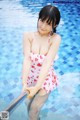 A woman in a pink bathing suit standing in a pool.