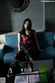 A woman sitting on a blue couch in a room.