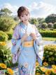 A woman in a blue kimono standing in a field of flowers.