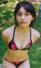 A woman in a black and red bikini posing for a picture.