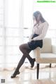 A woman sitting on a white chair in a room.